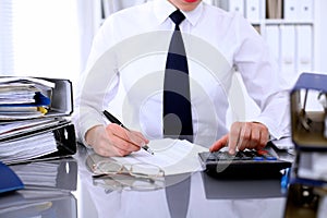 Close up of business woman making report, calculating or checking balance.