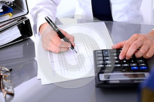 Close up of business woman making report, calculating or checking balance.
