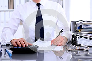 Close up of business woman making report, calculating or checking balance.