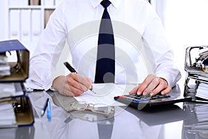 Close up of business woman making report, calculating or checking balance.