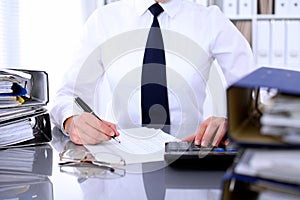 Close up of business woman making report, calculating or checking balance.