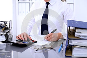 Close up of business woman making report, calculating or checking balance.