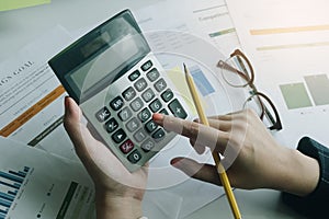 Close up Business woman using calculator for do math finance on wooden desk in office and business working background, tax,