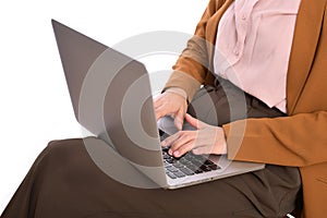 Close up of a business woman using laptop on her lap while sitting