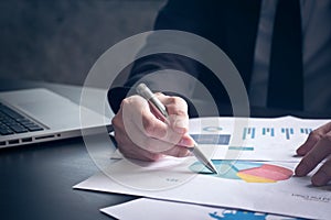 Close up of Businessman analyzing investment charts on the desk.