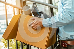 Close up businessman is carrying a brown cardboard box to resignation