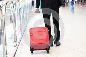 Close-up of businessman carrying suitcase while walking through a passenger boarding bridge