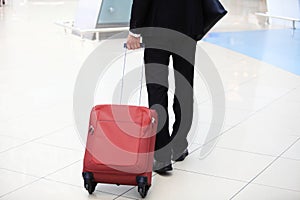 Close-up of businessman carrying suitcase while walking through a passenger boarding bridge
