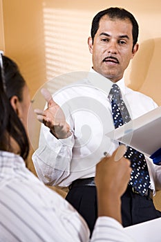 Close-up of businessman conversing with co-worker