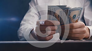 Close-up of a businessman counting money and beating his fist on the table. Cheating with payment.