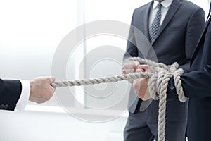 close up.businessman drags his business team by the rope