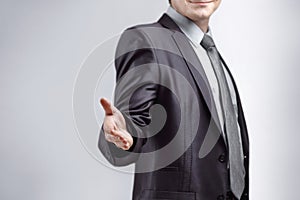 Close up. the businessman extends his hand for greeting .isolated on grey background