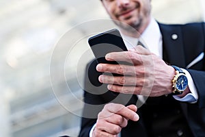 Close up businessman in formal suit use modern smartphone.