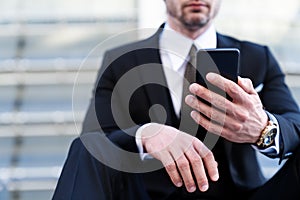 Close up businessman in formal suit use modern smartphone.