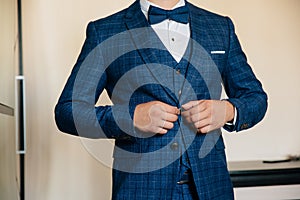Close-up businessman groom wearing his jacket. Concept of men stylish elegance clothes