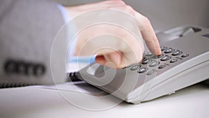 Close up of businessman hand dialing phone number