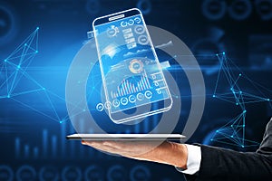 Close up of businessman hand holding digital blue smartphone with business chart on dark polygonal background. Analytics,