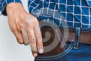 Close up Businessman hand pick the wallet from jeans pocket.