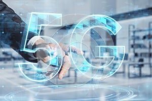 Close up of businessman hand pointing at abstract glowing 5G hologram on blurry office interior background. Mobile internet speed