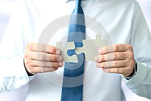 Close-up Of Businessman Hands Connecting Jigsaw Puzzle
