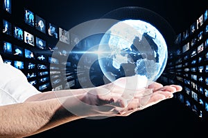 Close up of businessman hands holding creative glowing polygonal globe with rows of images on dark background. Connecting