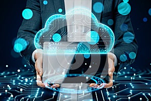 Close up of businessman hands holding tablet with creative cloud computing hologram on blurry bokeh background. Database and