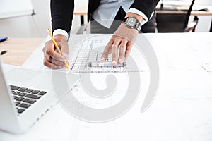 Close-up of businessman hands pointing pen to chart