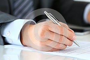 Close up of businessman hands signing documents photo