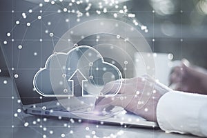 Close up of businessman hands using laptop at desktop with coffee cup and glowing cloud inside sphere connections on blurry