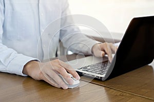 Close up, Businessman hands using mouse and computer laptop, browsing internet information and searching web, working outside