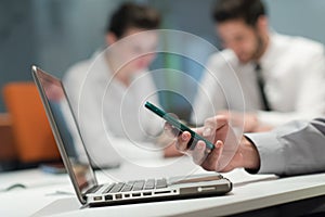 Close up of businessman hands using smart phone on meeting