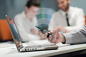 Close up of businessman hands using smart phone on meeting