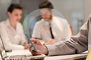 Close up of businessman hands using smart phone on meeting