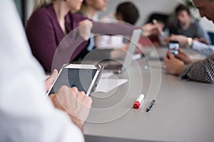 Close up of businessman hands using tablet on meeting