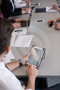 Close up of businessman hands using tablet on meeting