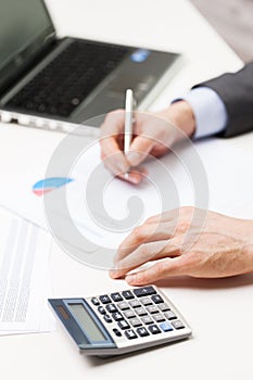 Close up of businessman with laptop and papers