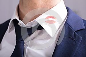 Businessman With Lipstick Kiss Marks On Shirt`s Collar photo