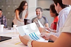 Close Up Of Businessman Looking At Profit Graph In Meeting