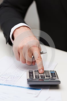 Close up of businessman with papers and calculator