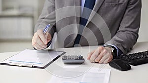 Close up of businessman with papers and calculator