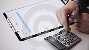 Close up of businessman with papers and calculator