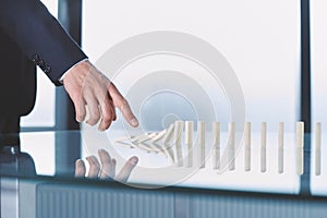 businessman pushing dominoes standing in a row.