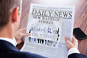 Close-up of businessman reading news on newspaper