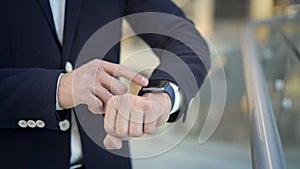 Close up of businessman s finger swiping to the left on smartwatch