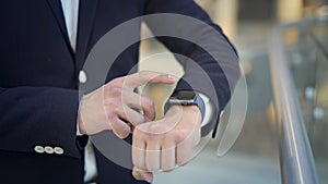 Close up of businessman s finger swiping to the left on smartwatch