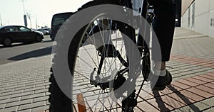 Close-up of a businessman`s foot in a suit and shoes pedal the bicycle.