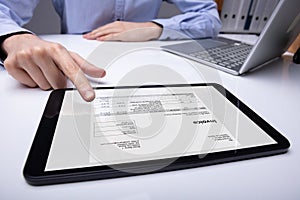 Businessman Checking Invoice On Tablet