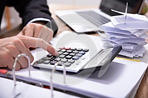 Businessman Using Calculator While Calculating Invoice