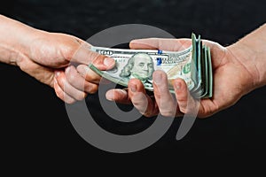 Close up of a businessman`s hands holding money over a black background