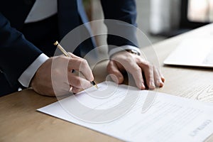 Close up businessman signing contract, making deal, filling legal document